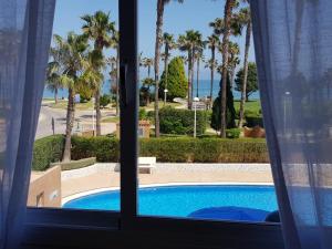 een raam met uitzicht op een zwembad bij Marina dor Frontal 1ª línea in Oropesa del Mar