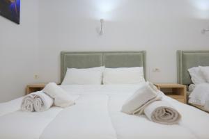Un dormitorio con una cama blanca con toallas. en Villa Gjika, en Qeparo