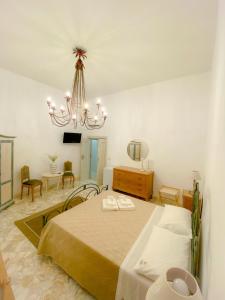 a bedroom with a bed and a chandelier at La Casa di Nonna Sisina in Mola di Bari