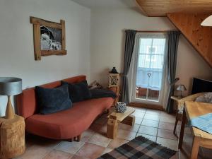 uma sala de estar com um sofá vermelho e uma janela em Fewo Holzwurm em Braunlage