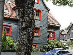 un coche aparcado frente a una casa con ventanas rojas en Fewo Holzwurm, en Braunlage