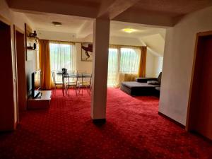 a living room with a couch and a red carpet at Pensiunea Riffelt in Bran