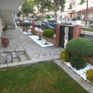 a stone walkway with trees and bushes in a yard at Appartment Sotirios in Tagarades