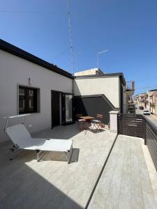 a patio with a white chair and a table on a building at Domus Solis in Pachino