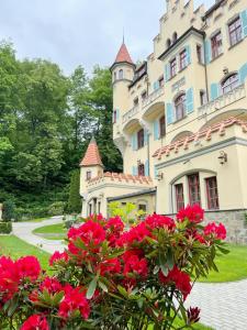 a large building with red flowers in front of it at Spa Hotel Villa Ritter in Karlovy Vary