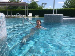 una mujer está en una piscina en Karos Gold 813 Wellness Apartman en Zalakaros