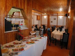 a dining room with a table with plates of food at Hotel Premier in Predeal