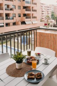 a table with two plates of food on a balcony at Patacona Beach Apartment in Alboraya
