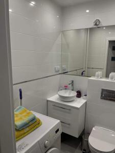 biała łazienka z umywalką i toaletą w obiekcie Apartament Dworcowa w Olsztynie