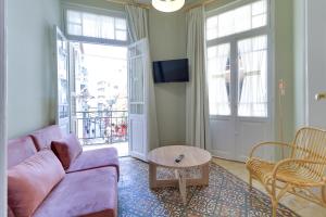 a living room with a purple couch and a table at athensvintage in Athens