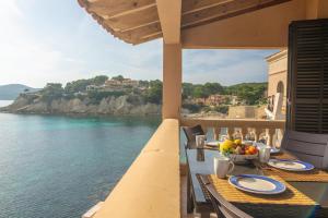 a table on a balcony with a view of the ocean at Vista Azul 1 in Sant Elm