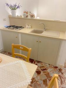 a kitchen with a sink and a stove and a table at La Casa di Nonna Sisina in Mola di Bari +17 photos