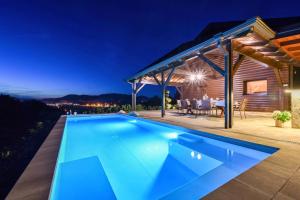- une piscine en face d'une maison la nuit dans l'établissement Ville Pačetina, à Lepajci