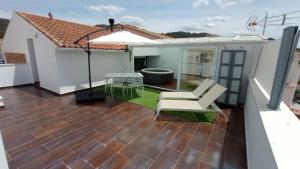 eine Terrasse mit 2 Stühlen und einem Sonnenschirm in der Unterkunft Casa Relojero in Zarza Capilla