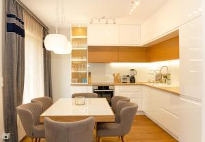 a kitchen with a dining room table and chairs at Designer 2-BD Apartment with Parking near Center of Varna in Varna City