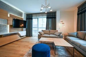 a living room with two couches and a tv at Designer 2-BD Apartment with Parking near Center of Varna in Varna City