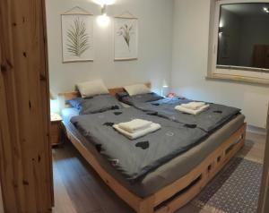 a bedroom with a bed with two towels on it at Mazury całoroczny dom do wynajęcia nad jeziorem in Pasym