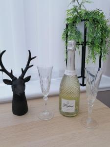 a bottle of wine and two glasses on a table at Curlew - Port Seton in Port Seton