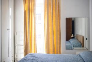um quarto com uma cama, um espelho e uma janela em Via Colombo em Marina di Massa