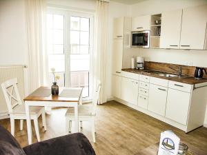 una cucina e una sala da pranzo con tavolo, una cucina e una sala da pranzo di Haus Götting Wohnung 2 a Norderney
