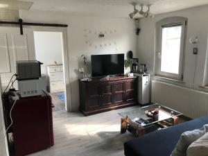 a living room with a flat screen tv and a couch at Ferienwohnung im Einfamilienhaus, Automobil und Robert Schumann Stadt Zwickau in Zwickau
