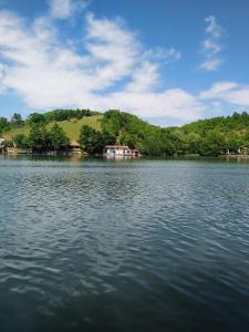 um grande lago com uma casa no meio dele em Kuća na obali jezera sa bazenom em Međuvršje