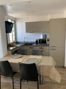 a kitchen with a table and chairs in a room at Bel appartement sur le port du Brusc avec sa place de parking privative. in Six-Fours-les-Plages