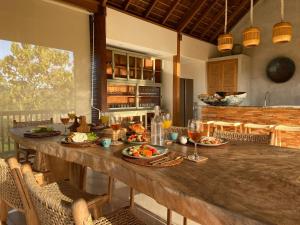 a kitchen with a large wooden table with food on it at Villa Biarritz in Uluwatu