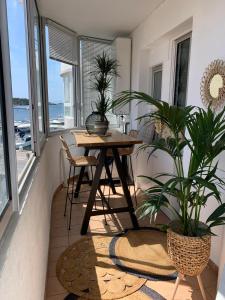 una sala da pranzo con tavolo e alcune piante di Bel appartement sur le port du Brusc avec sa place de parking privative. a Six-Fours-les-Plages