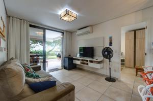 uma sala de estar com um sofá e uma televisão de ecrã plano em Wai Wai Cumbuco Apartamento Térreo em Cumbuco