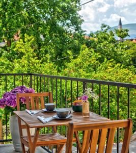 una mesa de madera con 2 cuencos y 2 sillas en el balcón en Villa Amaleo en Mostar