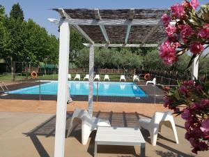 a swimming pool with a white pergola and a white bench at Las Ventas in Utebo