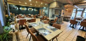 un comedor con mesas y sillas en un restaurante en La Vieille Ferme Chassepierre en Chassepierre