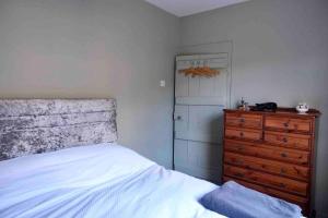 um quarto com uma cama e uma cómoda em madeira em Regency cottage 10 minutes from Bath city centre em Bath