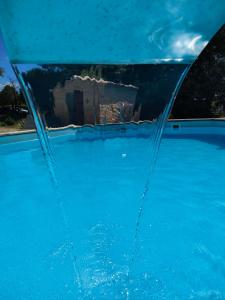 un reflejo de una casa en el parabrisas de un coche azul en O'fildl'eau gîte, en Sillans-la Cascade