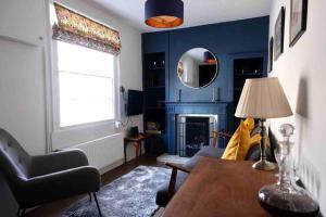 un salon avec une table et un mur bleu dans l'établissement Regency cottage 10 minutes from Bath city centre, à Bath