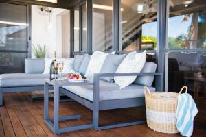 a blue couch and a table on a porch at Coral Sea Pearl in Shute Harbour