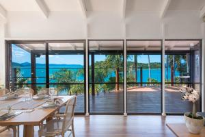 uma sala de jantar com uma mesa e vistas para o oceano em Coral Sea Pearl em Shute Harbour