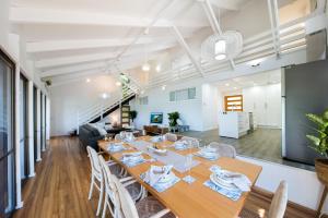 a dining room with a long table and chairs at Coral Sea Pearl in Shute Harbour +16 photos