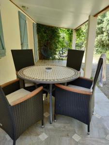 una mesa y sillas en un patio en O'fildl'eau gîte, en Sillans-la Cascade
