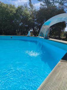 una fontana in una piscina blu di O'fildl'eau gîte a Sillans-la Cascade