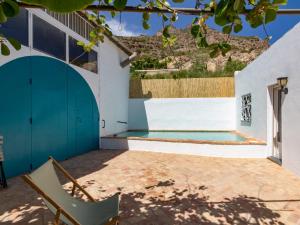 a patio with a chair and a swimming pool at Casa Ishtar in Nigüelas