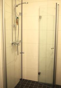 y baño con ducha y puerta de cristal. en City Center 2-rooms apartment, en Vaasa