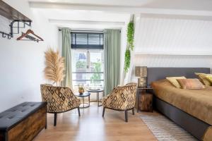 een slaapkamer met een bed en stoelen en een raam bij Zandvoort-17 in Zandvoort