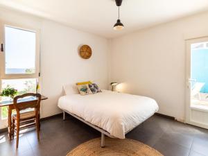 a bedroom with a bed and a desk and windows at Casa Ishtar in Nigüelas