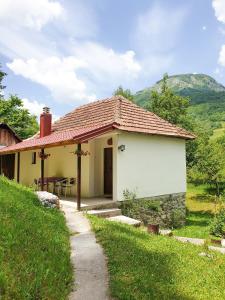 een klein wit huis met een tafel en stoelen bij Farmstead Green Haven in Mojkovac