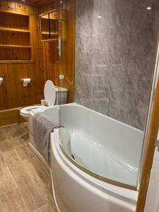 a bathroom with a bath tub and a toilet at Relaxing costal retreat sleeps four people in Hastings