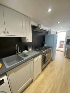 a kitchen with a sink and a refrigerator at Relaxing costal retreat sleeps four people in Hastings