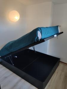 uma cama com uma almofada azul numa prateleira em Gap, appartement calme au coeur de la vielle ville em Gap