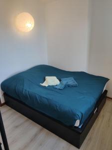 uma cama num quarto com um cobertor azul em Gap, appartement calme au coeur de la vielle ville em Gap